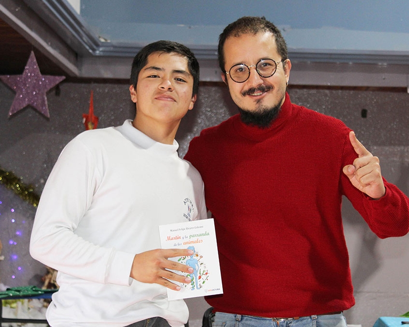 Escritor entrega libro a estudiante