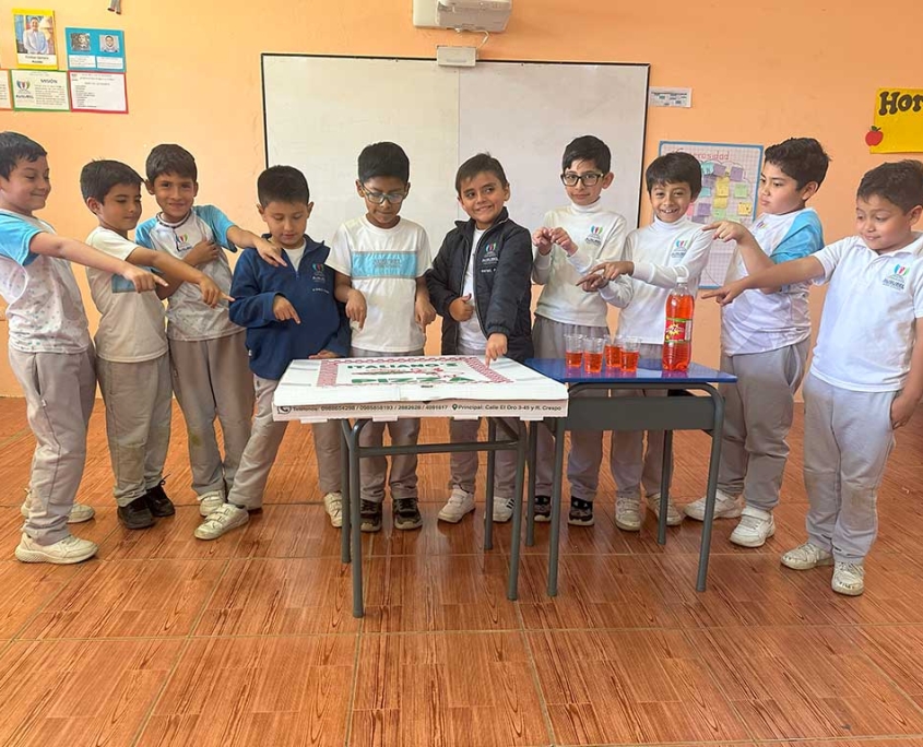 Curso ganador en el Spooky Day, señalando la pizza que ganaron